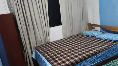 a bedroom with a bed with a checkered blanket and a window at Hospedaje D'LEYDI in Lima
