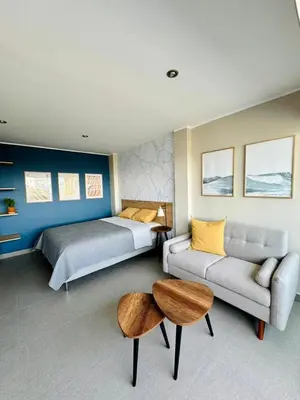 a bedroom with a bed and a couch and a table at Almar Punta Hermosa in Punta Hermosa