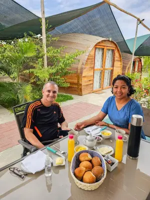 a man and a woman sitting at a table with food at Viñedo Sotelo - Hospedaje y Glamping in San Juan Bautista