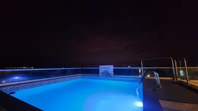 a swimming pool at night with the lights on at Casa de Playa en Cerro Azul in Cerro Azul
