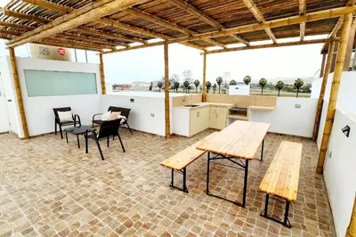 a room with wooden tables and chairs and a kitchen at Casa de Playa en Cerro Azul in Cerro Azul