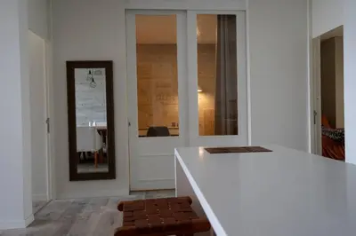 a white kitchen with a counter and a mirror at 3BR Paracas Kite Gym Work Oasis in Santo Domingo