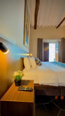 a bedroom with a bed and a table with a remote control at Andean Palace Boutique in Cusco