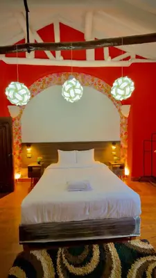 a bedroom with a large white bed with a red wall at Andean Palace Boutique in Cusco