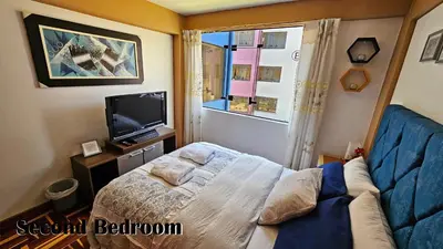 a small bedroom with a bed and a television at Puma Wasi, céntrico, acogedor, bien iluminado in Cusco