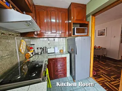 a kitchen with wooden cabinets and a white refrigerator at Puma Wasi, céntrico, acogedor, bien iluminado in Cusco