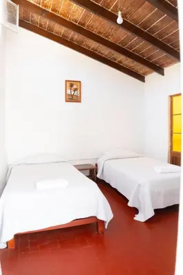 two beds in a room with white walls at HAWKA in Ica
