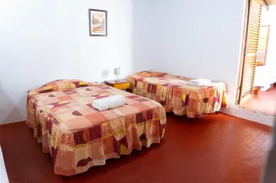 a room with two beds and a window at HAWKA in Ica