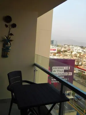 a table and a chair in front of a window at Loft de estreno, San Borja, muy centrico in Lima