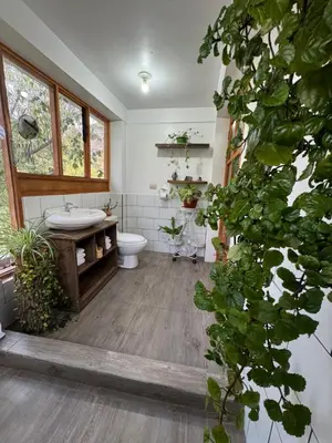 a large bathroom with a toilet and a sink at Spirit Of The River Lodge in Cusco