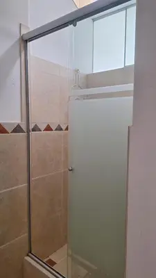 a shower with a glass door in a bathroom at Adri s House in Lima