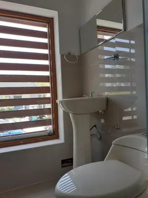 a bathroom with a sink and a toilet and a window at Adri s House in Lima