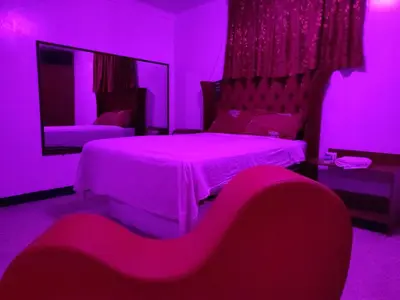a purple room with a bed and a mirror at Hostal Reyna in Lima