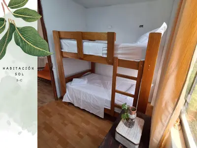 a room with two bunk beds and a table at Casa Vacacional Puro Jita in Lunahuaná