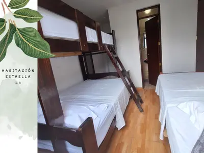 a bedroom with two bunk beds with white sheets at Casa Vacacional Puro Jita in Lunahuaná