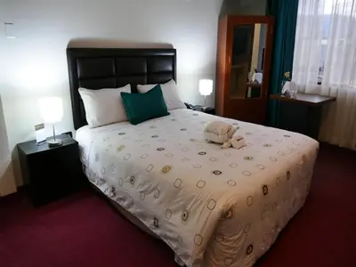a bedroom with a large bed with a stuffed animal on it at Blub Hotel Spa in Huancayo