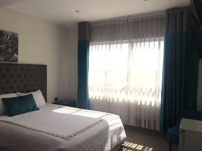 a bedroom with a bed and a large window at Blub Hotel Spa in Huancayo