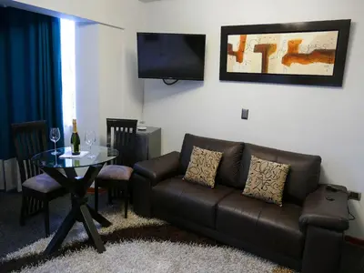 a living room with a leather couch and a table at Blub Hotel Spa in Huancayo