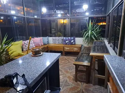 a screened in porch with couches and tables in a room at Yllari's Inn in Cusco