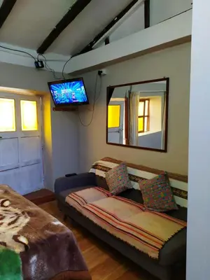a living room with a couch and a mirror at Yllari's Inn in Cusco