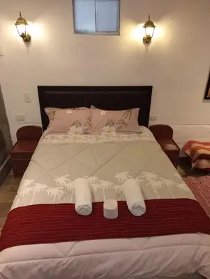 a bedroom with a large bed with towels on it at Yllari's Inn in Cusco