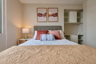 a bedroom with a large bed with pink pillows at ALU Apartments - Miraflores Boardwalk, Wifi 70M in Lima