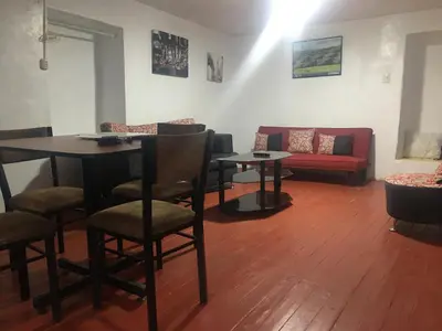 a living room with a table and chairs and a couch at Washichay in Cusco
