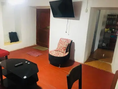 a living room with a chair and a television at Washichay in Cusco