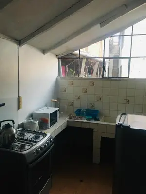 a kitchen with a stove and a sink and a window at Washichay in Cusco