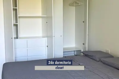 a bedroom with a bed and some shelves at 2BR Apartamento Moxie Paracas con Terraza y AC en 1r Piso in Paracas