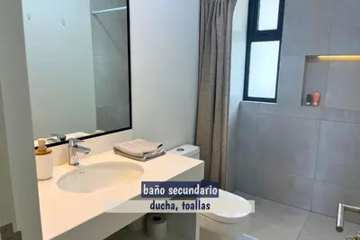 a bathroom with a sink and a toilet and a mirror at 2BR Apartamento Moxie Paracas con Terraza y AC en 1r Piso in Paracas