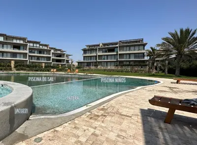 a swimming pool in front of some apartment buildings at 2BR Apartamento Moxie Paracas con Terraza y AC en 1r Piso in Paracas