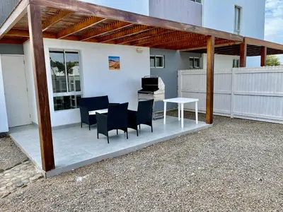 a patio with chairs and a table and a grill at 1er Piso Vista a Bahía Paracas - Las Velas 102 T1 in Paracas
