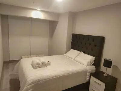a bedroom with a bed with two towels on it at Audacity Moderno Departamento in Lima