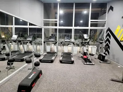 a gym with several treadmills and machines at Audacity Moderno Departamento in Lima