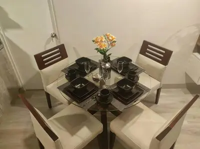 a table with two chairs and a vase with flowers on it at Audacity Moderno Departamento in Lima