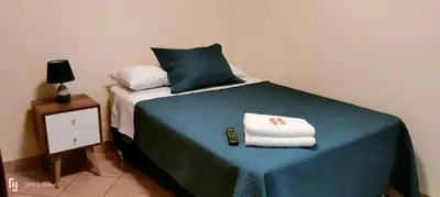 a bed with two towels and a remote control on it at Warmisitay HOME individual in Lima