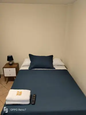 a bedroom with a bed with a remote control on it at Warmisitay HOME individual in Lima