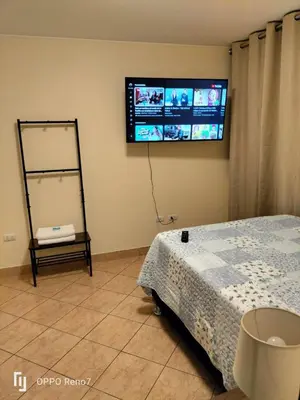 a bedroom with a bed and a tv on the wall at Warmisitay HOME individual in Lima