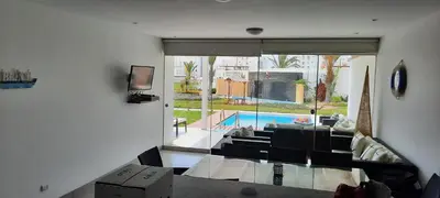 a living room with a view of a pool at Condominio Nautico Paracas in Pisco