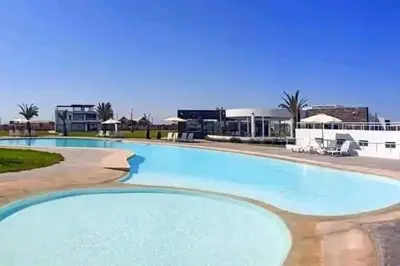 a large blue swimming pool in a resort at Condominio Nautico Paracas in Pisco