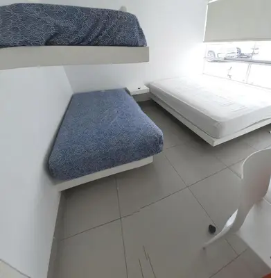 a small room with a bed and a bench at Condominio Nautico Paracas in Pisco