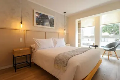 a bedroom with a large bed and a chair at Mirano by Wynwood House in Lima