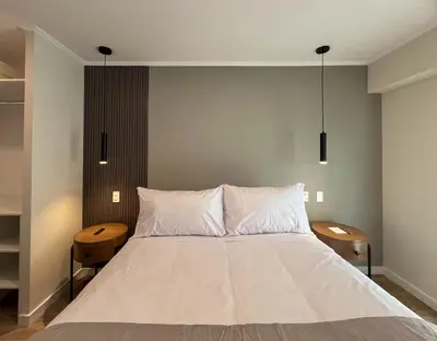 a bedroom with a large white bed with two tables at Mirano by Wynwood House in Lima