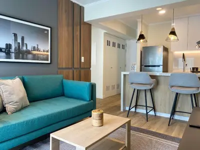 a living room with a couch and a kitchen at Mirano by Wynwood House in Lima