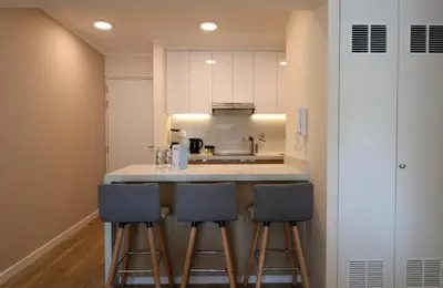 a kitchen with three bar stools and a sink at Mirano by Wynwood House in Lima