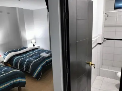 a bedroom with a bed and a bathroom with a shower at Alemar's House in Nazca