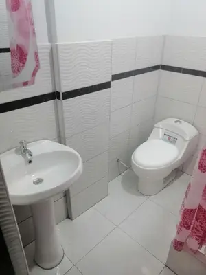 a white bathroom with a sink and a toilet at Alemar's House in Nazca