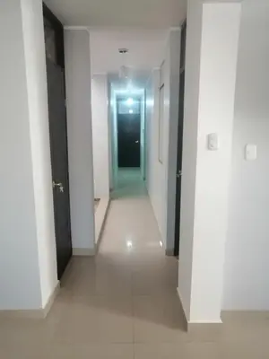 a hallway with white walls and a black door at Alemar's House in Nazca