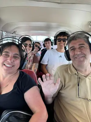 a group of people sitting in a bus wearing headphones at Alemar's House in Nazca